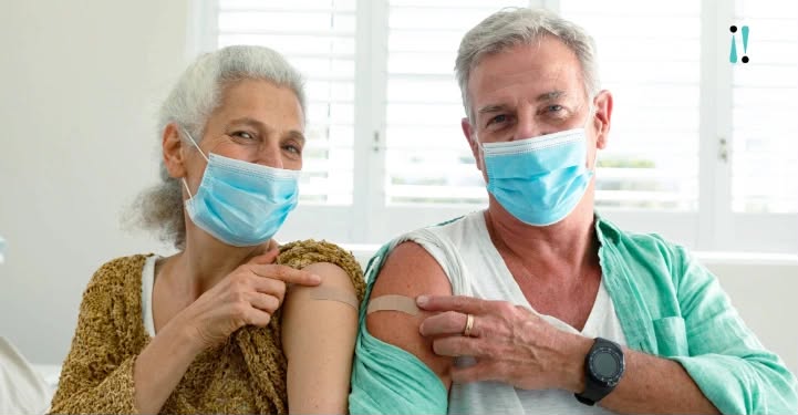 Casal de Pessoas Idosas vacinado, com máscaras de proteção